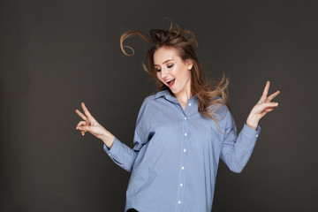 Cheerful lady posing over dark background