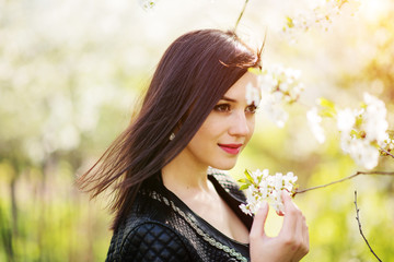 Close up portrait of young brunette girl with cherry blossom at