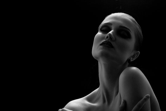 happy luxury woman model with professional makeup on black background monochrome