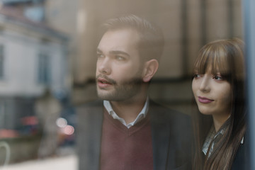Two young people looking through the office window