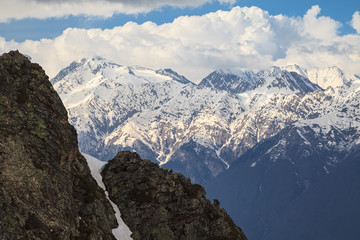 Beautiful scenic winter mountain landscape of the Main Caucasus ridge with snowy peaks and blue sky with clouds