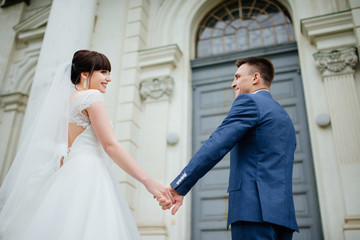 Obraz premium Wedding. Wedding day. Wedding couple. Beautiful couple, bride and groom look at each other and smiling against a white castle