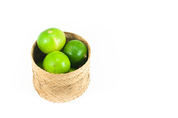 fresh green limes in the bamboo basket isolated on white background,Closeup shoot, Select focus