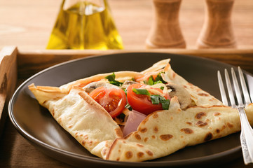 Pancakes sutffed with ham, cheese, tomatoes and mushrooms.