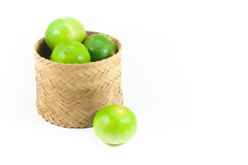 fresh green limes in the bamboo basket isolated on white background,Closeup shoot, Select focus