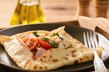 Pancakes sutffed with ham, cheese, tomatoes and mushrooms.