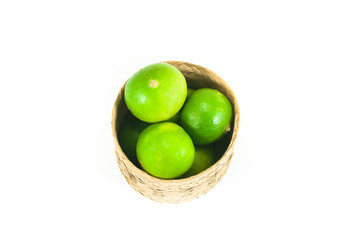 fresh green limes in the bamboo basket isolated on white background,Closeup shoot, Select focus