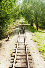 Narrow-gage railway rails at summer sunny day