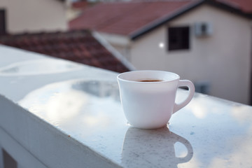 Чашка утреннего кофе на фоне городских крыш.