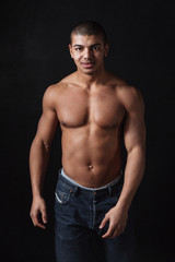 Fototapeta premium Cheerful young african sportsman posing over black background
