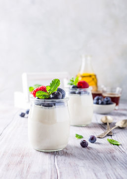Natural yoghurt with berries on light gray background. Copy space. Healthy breakfast concept.