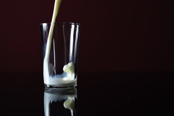Pouring milk into empty glass.