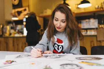 Fototapeta premium beautiful girl drawing with pencil in cafe