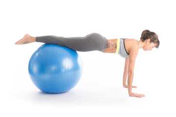 Beautiful fitness woman doing pilates exercises with fit ball. Isolated on white.