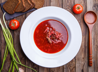 Beet soup in white plate with vegetables