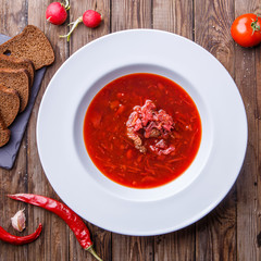Beet soup in white plate with vegetables
