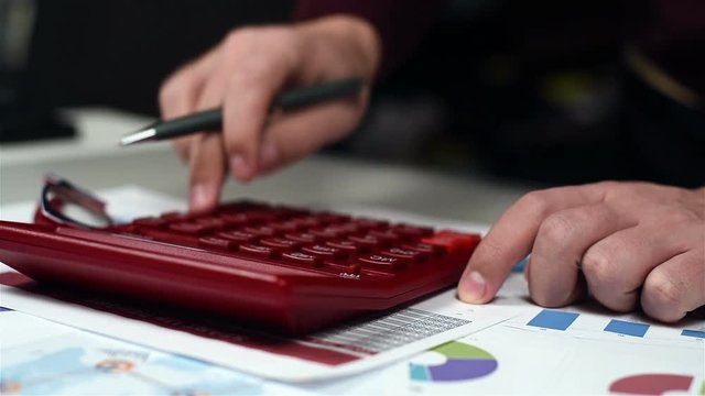 Accountant Hand Using Red Calculator. Business Concept. Close Up