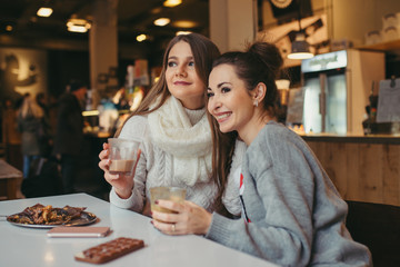 two girls driking coffee in cafe