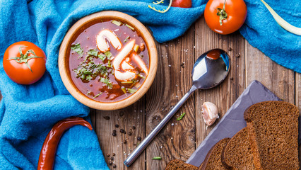 Beet soup in wooden plate with vegetables