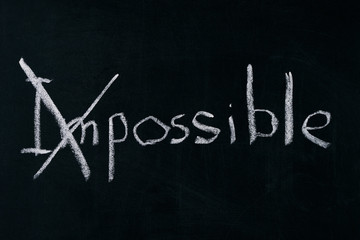 Obraz premium Changing the word impossible to possible on chalkboard.Motivation concept.