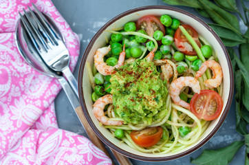 Zucchini pasta with shrimps and avocado in the bowl. Love for a healthy food concept