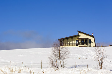 Fototapeta na wymiar Homes in the mountains in winter landscape