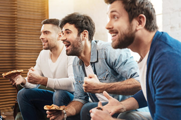 Positive joyful friends enjoying their pizza