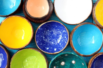 Many different bright multicolored ceramic bowls and cups handcrafted. Top view. View from above....
