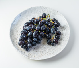 Grapes on the white table on the marble plate