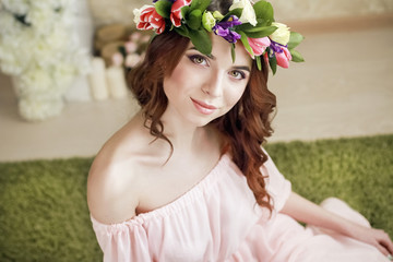 Naklejka premium Gentle romantic appearance of the girl with a wreath of roses on her head and a pink dress. Joyful Jolly spring woman. Summer lady in long pink dress