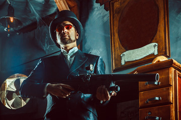 Mature gentleman with a rifle on the dark room background.