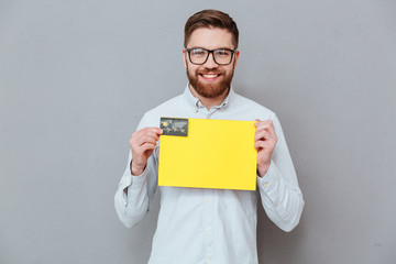 Handsome businessman holding copyspace blank and debit card