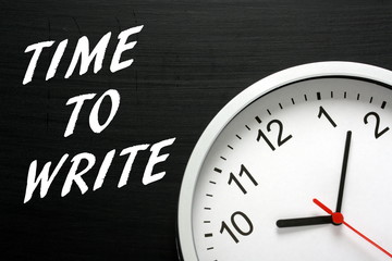 The words Time To Write in white text on a blackboard next to a clock as a reminder to aspiring authors to get down to work