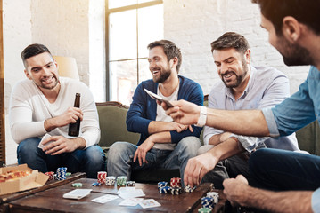 Cheerful pleasant men playing the poker game