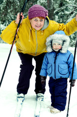 Little boy and old woman in winter forest on a ski trip