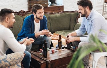 Delighted positive man shuffling cards