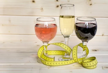 Acrylic prints Alcohol glasses of wine and champagne with  measuring tape.Calories in alcohol are extra-fattening 