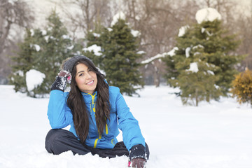 Fototapeta na wymiar beautiful smiling young woman sitting in the snow in the mountain .Winter holidays
