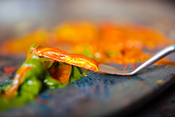 Close up of a putty knife mixing paints