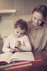 Obraz na płótnie Canvas Little girl drawing with her mom.