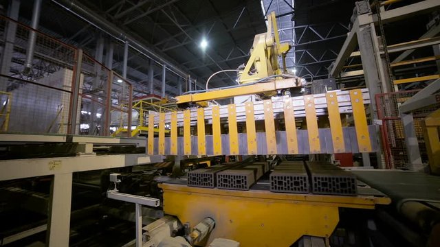 Industrial automation. Robotic Arm Assembling new building materials on conveyor belt. HD.