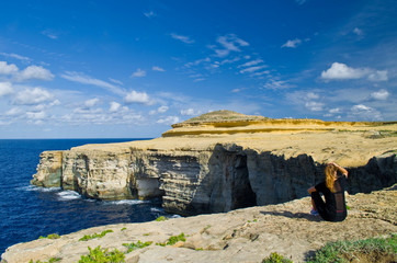 Malta cliff shore and women sitting on cliff - 135572917