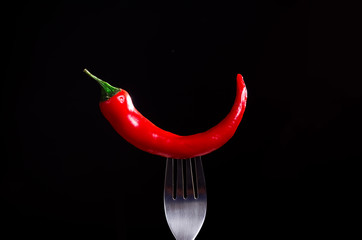 smoking chili pepper on fork on black background - 135572931