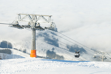 New cable cars going up and down the mountains at a winter sports resort area on a sunny day