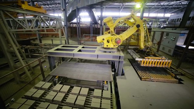 Industrial robotic arm manufacturing bricks. HD