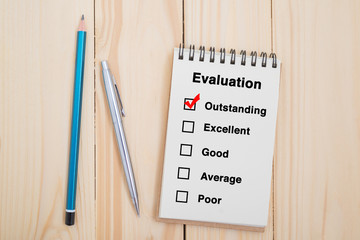 Performance evaluation check box on notebook with pen and pencil
