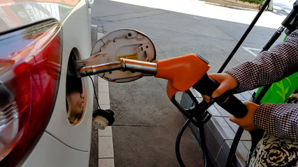Driver inserting pumping nozzle with gasoline at the gas station