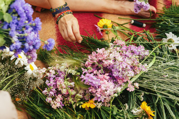 Young hipster women making flower wreaths circle closeup