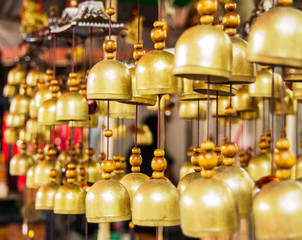 Obraz premium many brass bells hanging on the rope in the shop , selective focus bell