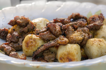 grilled meat and fishballs on white plate, selective focusing cl